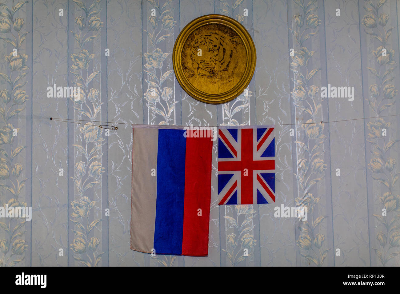 Die beiden Flaggen von Großbritannien und Russland hängen unter einer goldenen Platte mit sibirischem Tiger in der Mitte. Stockfoto
