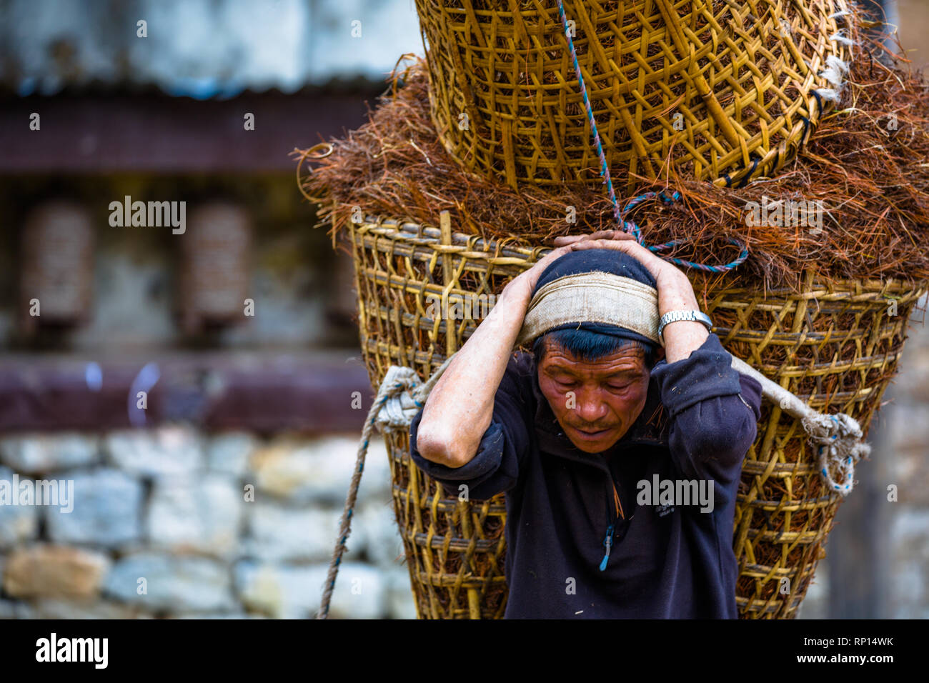 Ein Mann trägt 2 schwere Taschen von Produzent von Lukla, Namche, Nepal Stockfoto