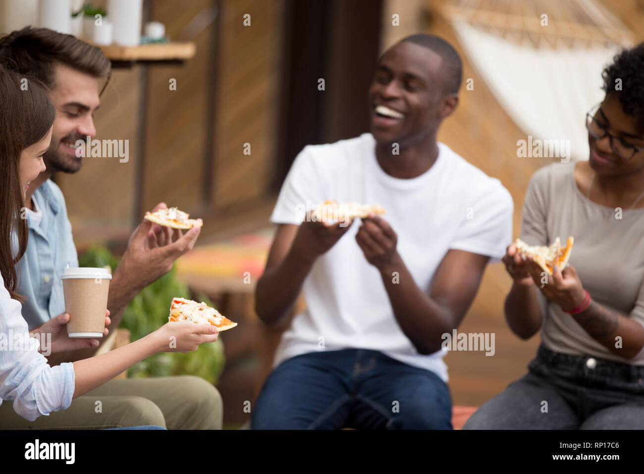 Fröhliche diverse Studenten machen eine Pause essen Pizza trinken Kaffee Stockfoto