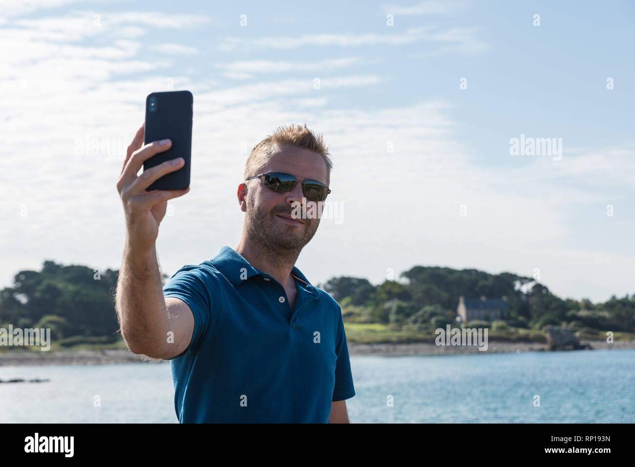 Mann eine selfie mit einem Smartphone am See Stockfoto