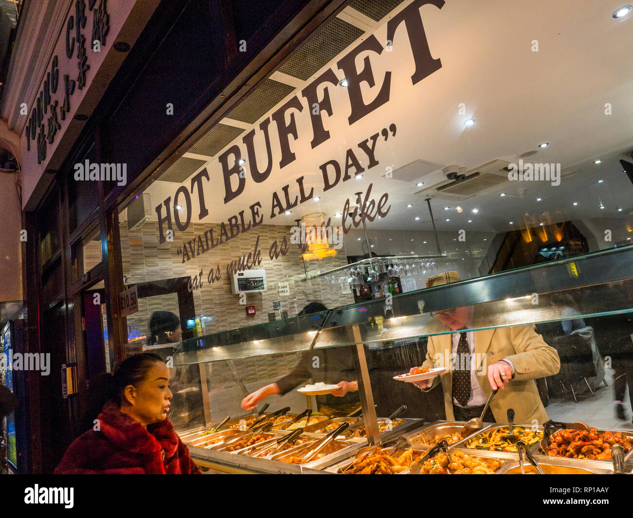 Chinesische warmes Buffet Auswahl' Essen, so viel Sie möchten 'Fenster, mit orientalischen Frau anerkennend auf die chinesische Küche Sorten auf "Offen" anzeigen. Wardour Street Chinatown Soho London UK Stockfoto