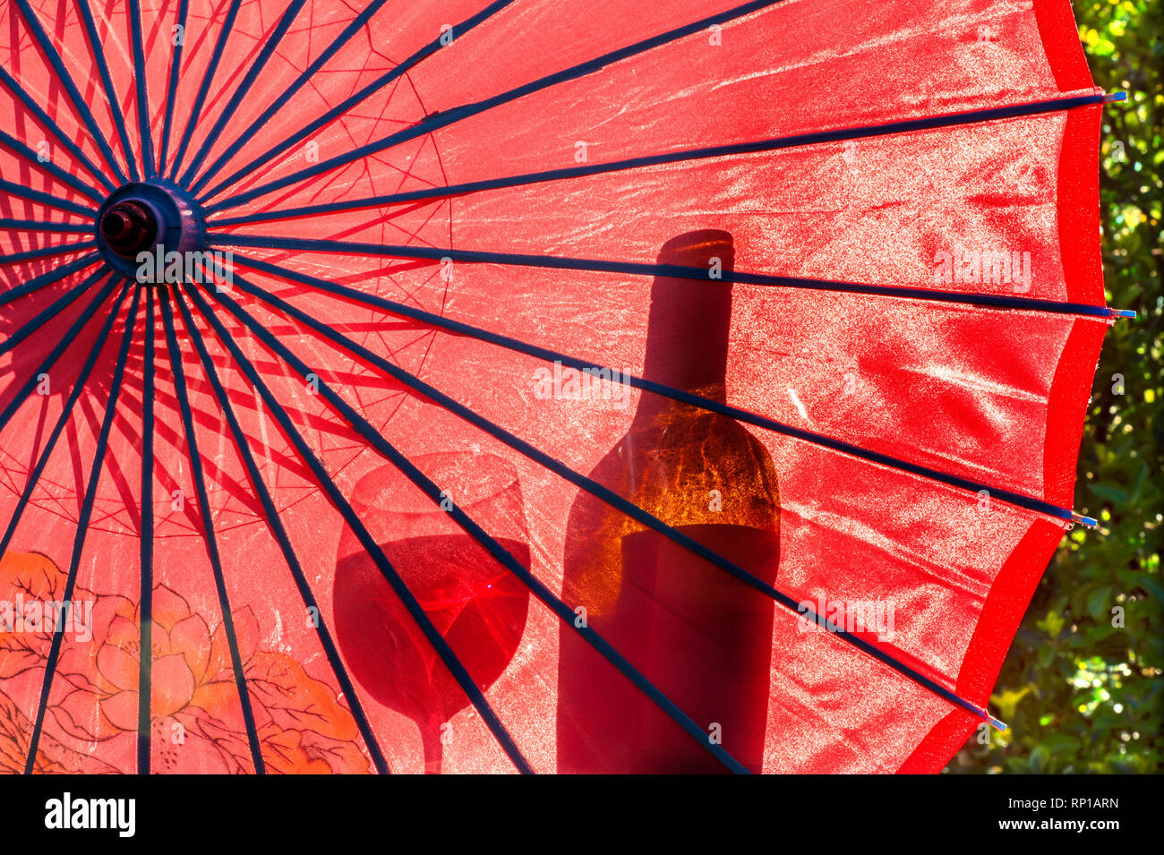 Im Freien Sommer Weinprobe Trinkpicknick mit rotem Sonnenschirm Sonnenschirm und Silhouette der Weinflasche und ein Glas Wein in Outdoor Sommerurlaub Sonne sonnige Lage Stockfoto