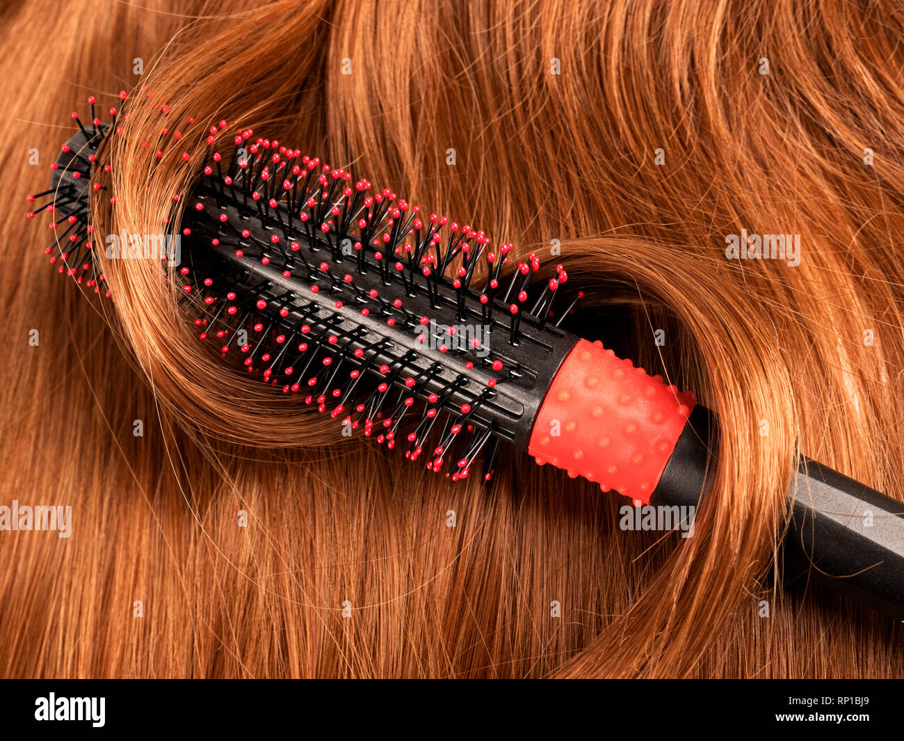 Roten Wellenlinien menschliches Haar Hintergrund mit einem Kamm Stockfoto