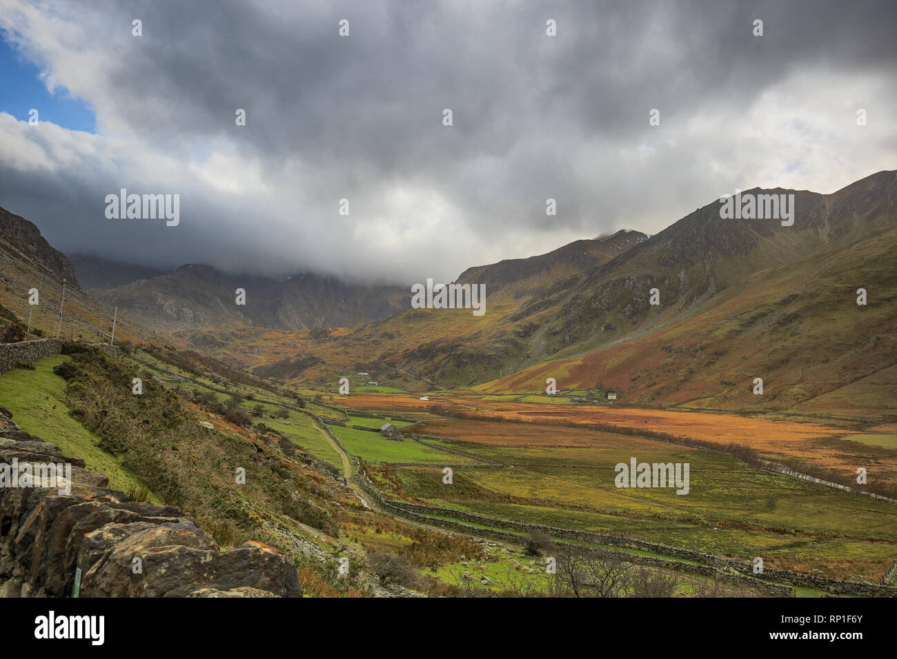 Ikonische, klassische Fotografie Landschaft Blick auf grüne Waliser Tal (ab A5) mit umliegenden Berge von Snowdonia Nationalpark & stürmischen Wolken über. Stockfoto