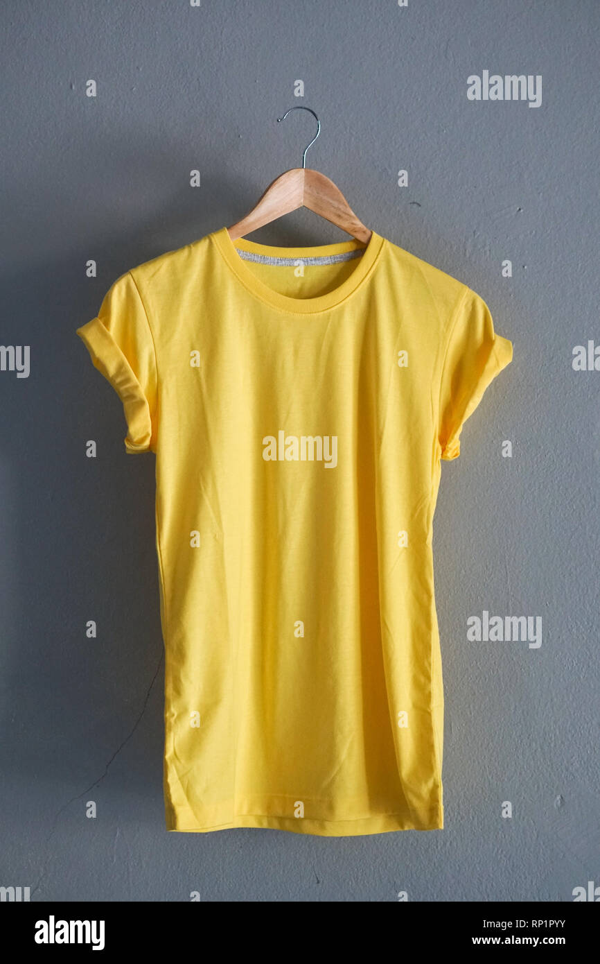 Retro fach Gelb T-Shirt Kleidung farbenfrohe Mock up Vorlage auf grunge weiß Holz Hintergrund Konzept für den Einzelhandel Dress Shop Kulisse, Leer Flachbild Stockfoto
