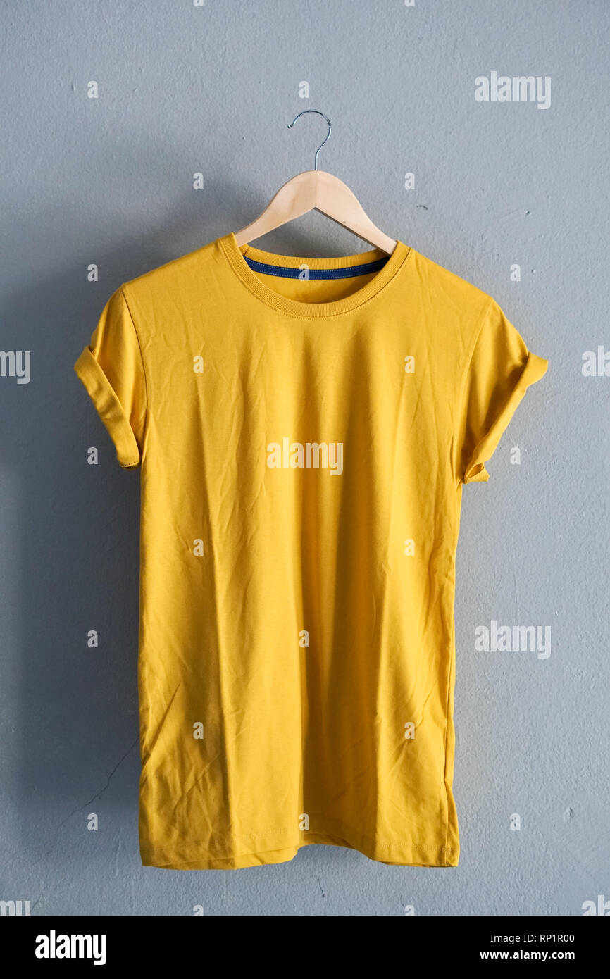 Retro fach Gelb T-Shirt Kleidung farbenfrohe Mock up Vorlage auf grunge weiß Holz Hintergrund Konzept für den Einzelhandel Dress Shop Kulisse, Leer Flachbild Stockfoto