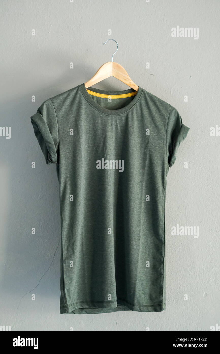 Retro Falten grüne T-Shirt aus Baumwolle Kleidung mock up Vorlage auf grauzement Hintergrund Konzept für den Einzelhandel Dress Shop Kulisse, Leere flach Vintage Grau Stockfoto