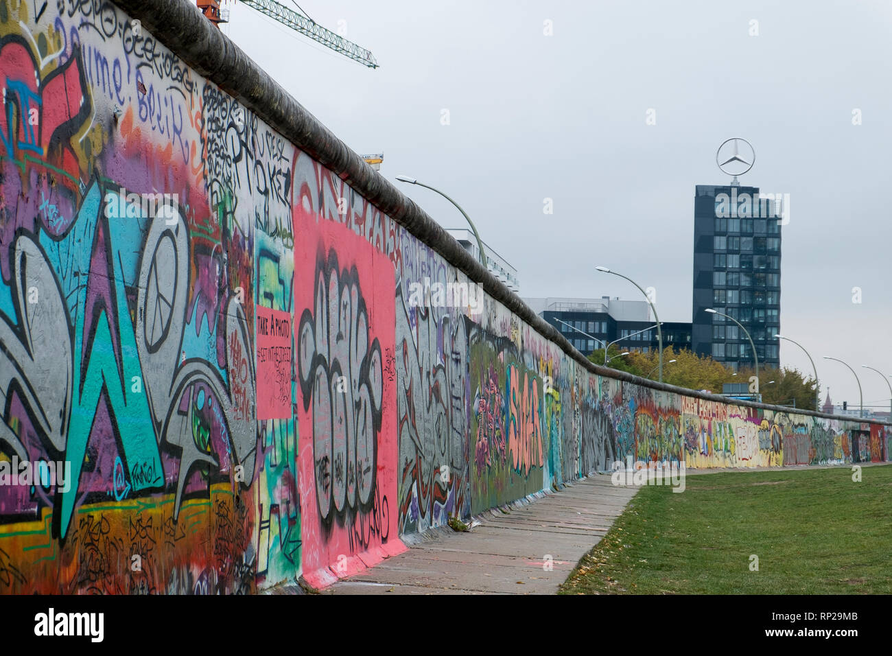 Eine Ausdehnung der Berliner Mauer, progrss im Hintergrund in Form einer Mercedes Benz Office Tower in Berlin, Deutschland. Stockfoto