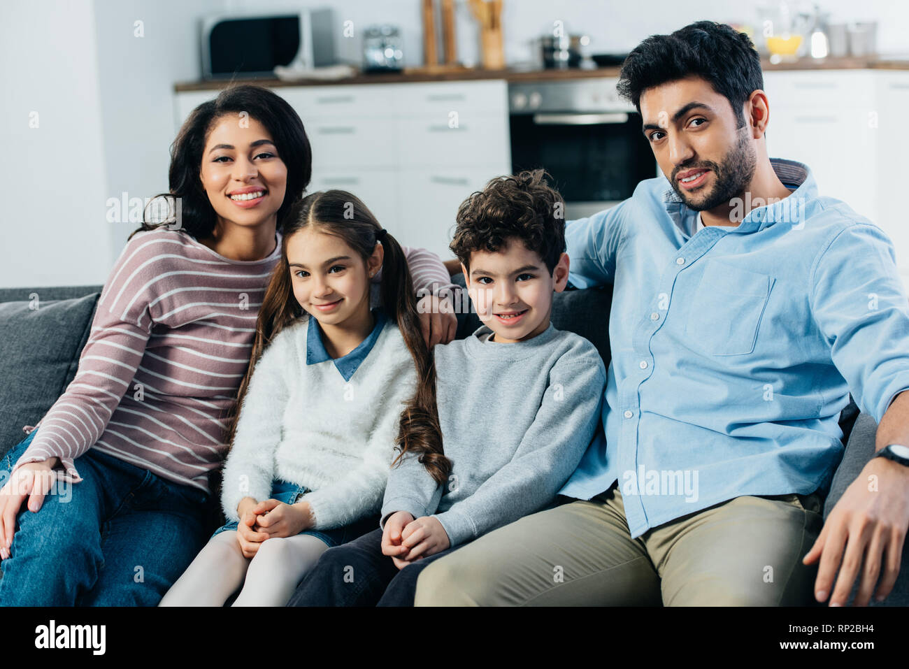 Happy spanischer Familie sitzt auf dem Sofa und zu Hause lächeln Stockfoto