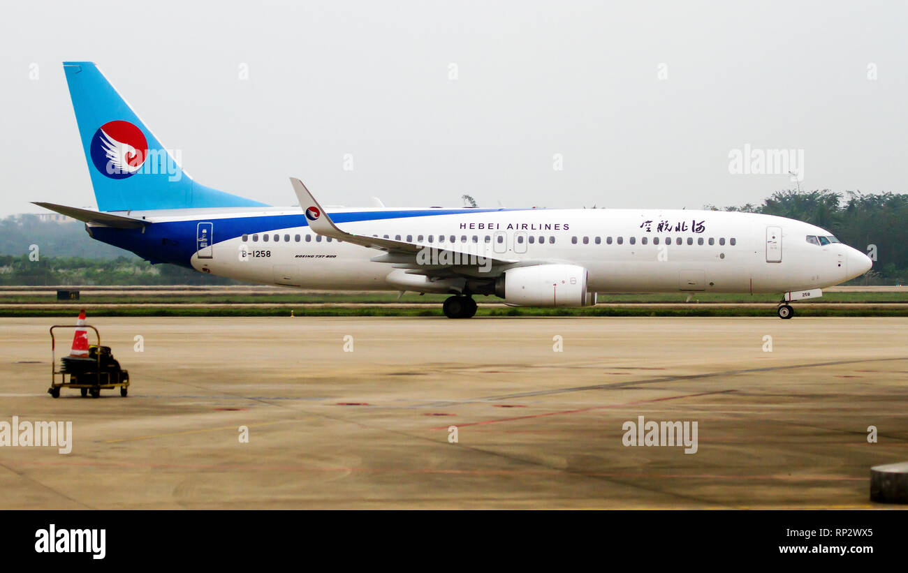 Eine Hebei Airlines Boeing 737-800 zum Tor an Hiakou Flughafen. Stockfoto