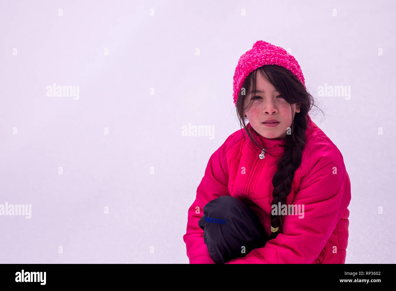 Junge asiatische Mädchen mit rosa Hut und Jacke im Schnee Stockfoto