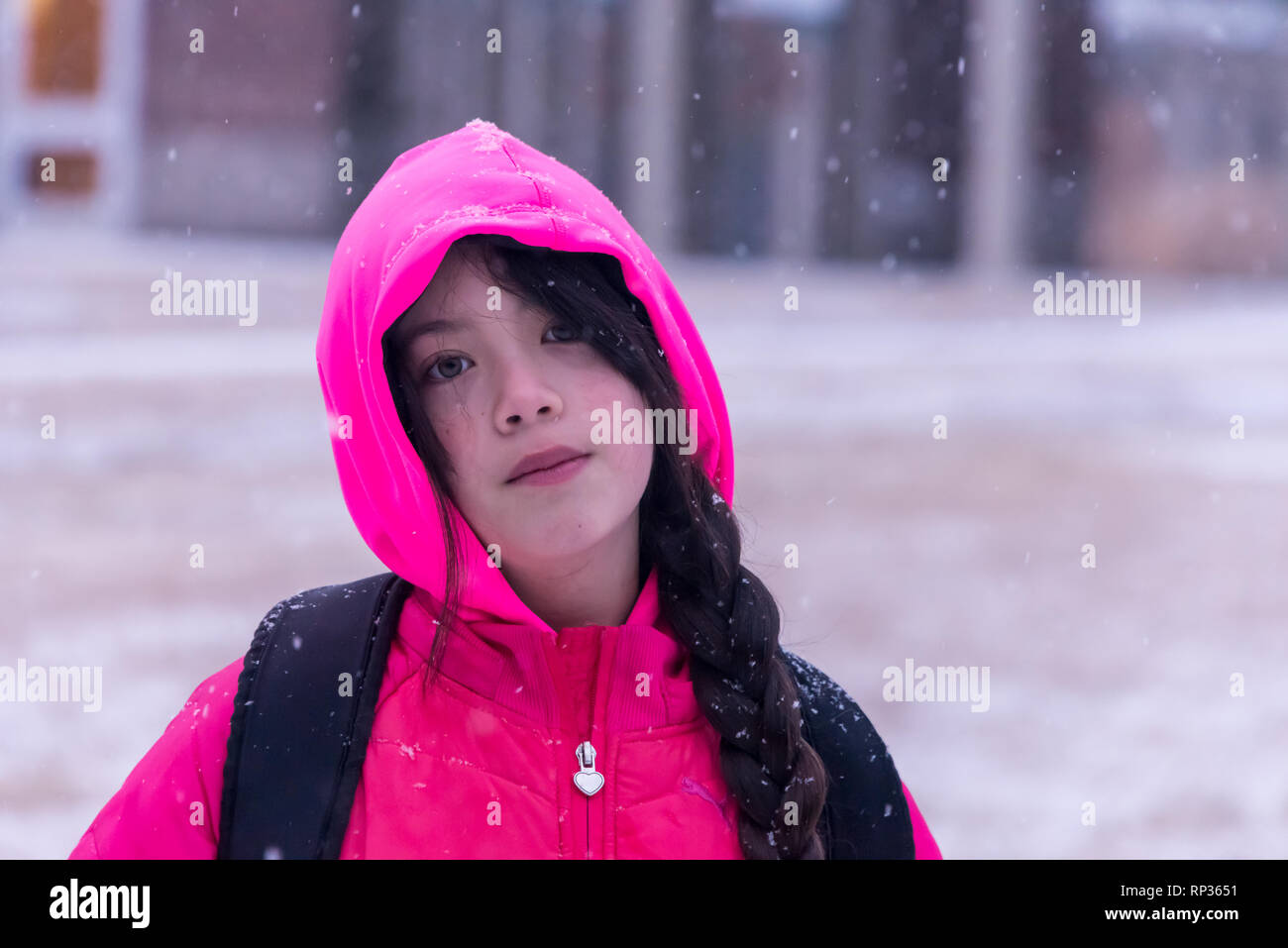 Junge asiatische Mädchen mit rosa Jacke mit Kapuze stand vor der Gebäude Stockfoto