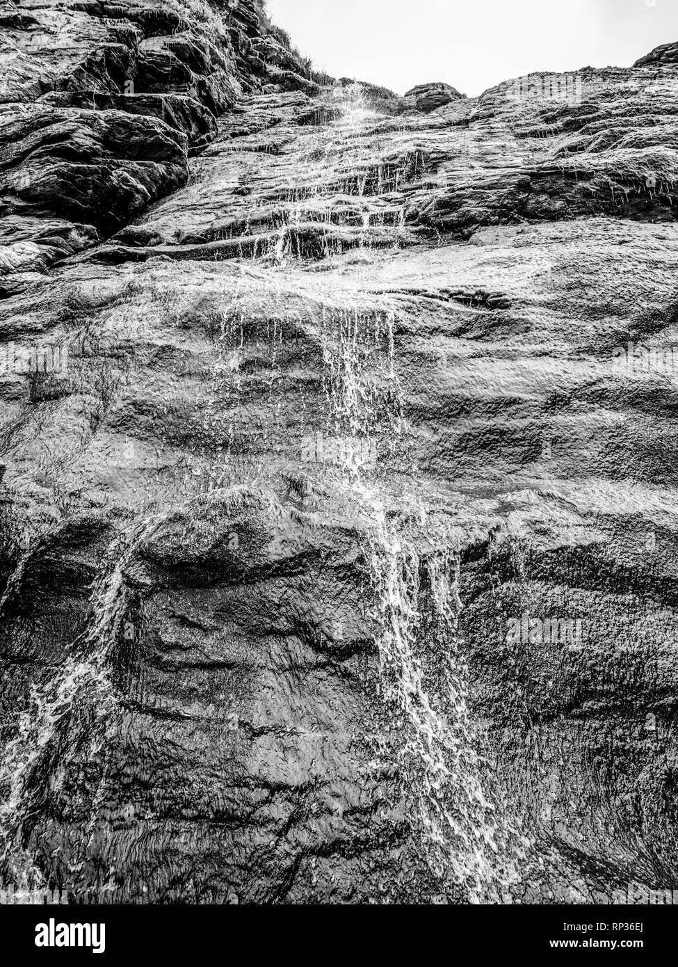 Schönen Wasserfall über Bemooste Steine in der Bucht von Tintagel in Cornwall. Stockfoto