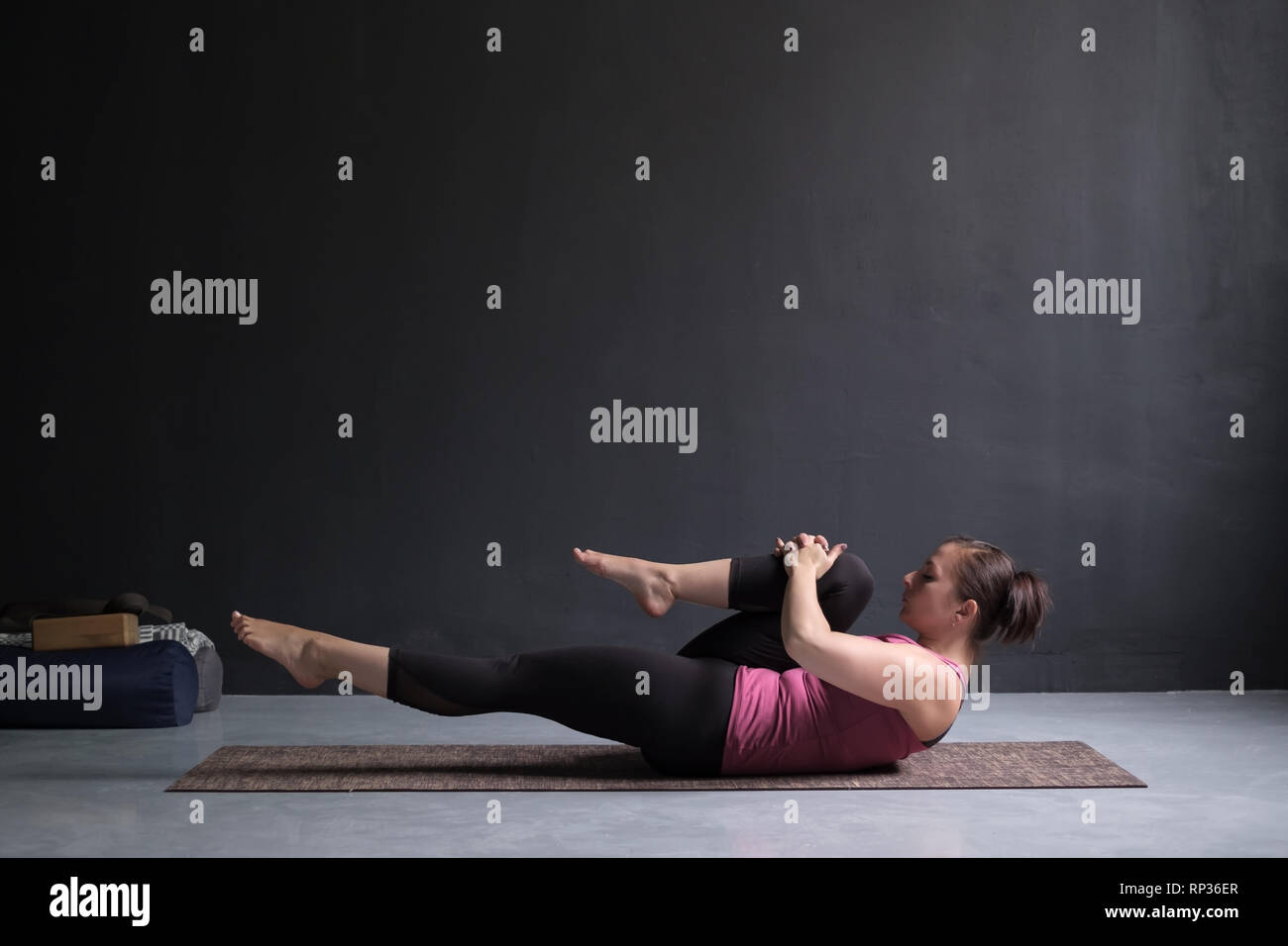 Frau tun Hatha Yoga Asana Ardha pawanmuktasana oder Knie zur Brust dar. Stockfoto