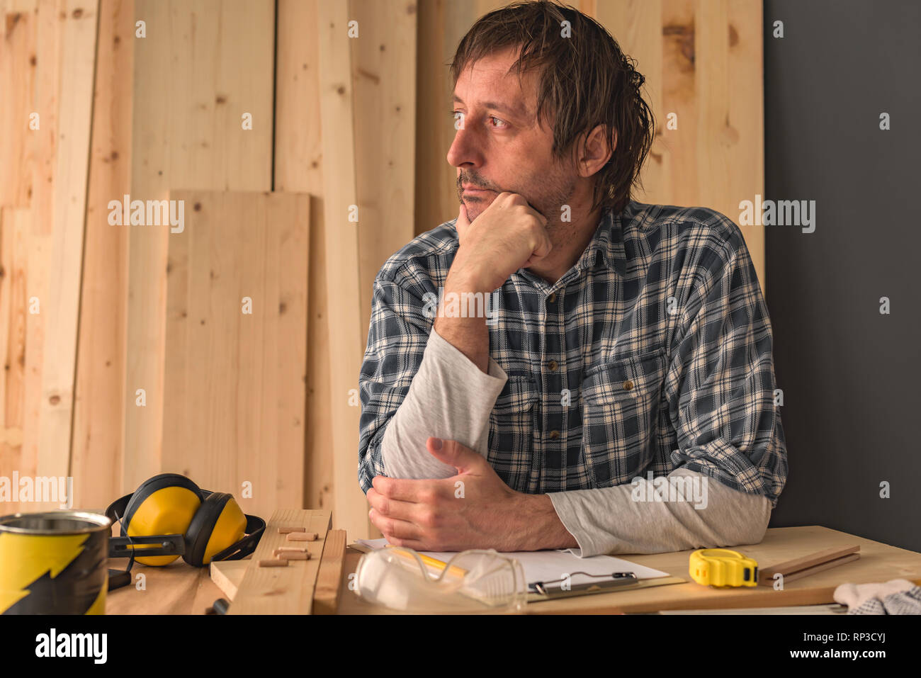 Tischler Denken in Small Business Holzarbeiten workshop Innenraum, nachdenklich nachdenklich männlich ist der Betrachtung und Planung neuer DIY-Projekt Stockfoto