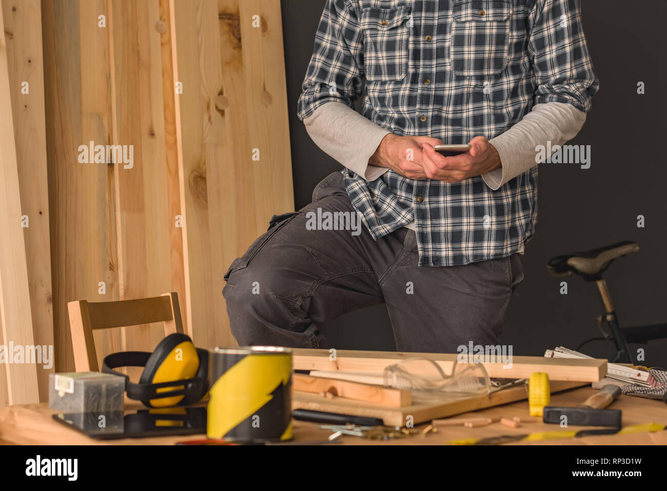 Tischler mit Smartphones in kleinen Unternehmen Holzarbeiten Workshop für die Planung einer neuen DIY-Projekt Stockfoto