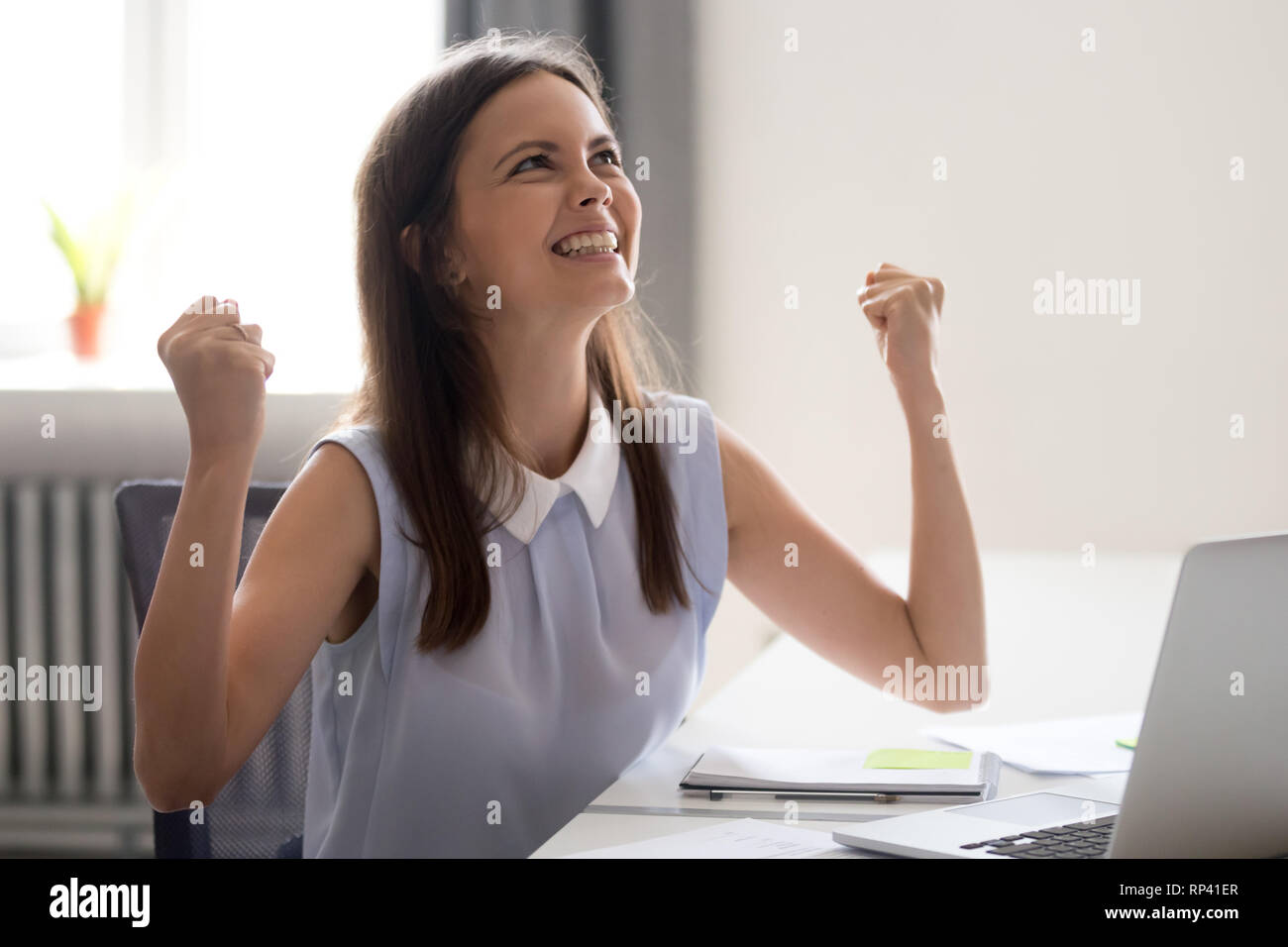 Junge attraktive Frau gerne am Schreibtisch gegenüber Computer sitzen fühlt  sich Aufregung um monetäre Belohnung für gute produktive Arbeit,  erfolgreiche completio Stockfotografie - Alamy