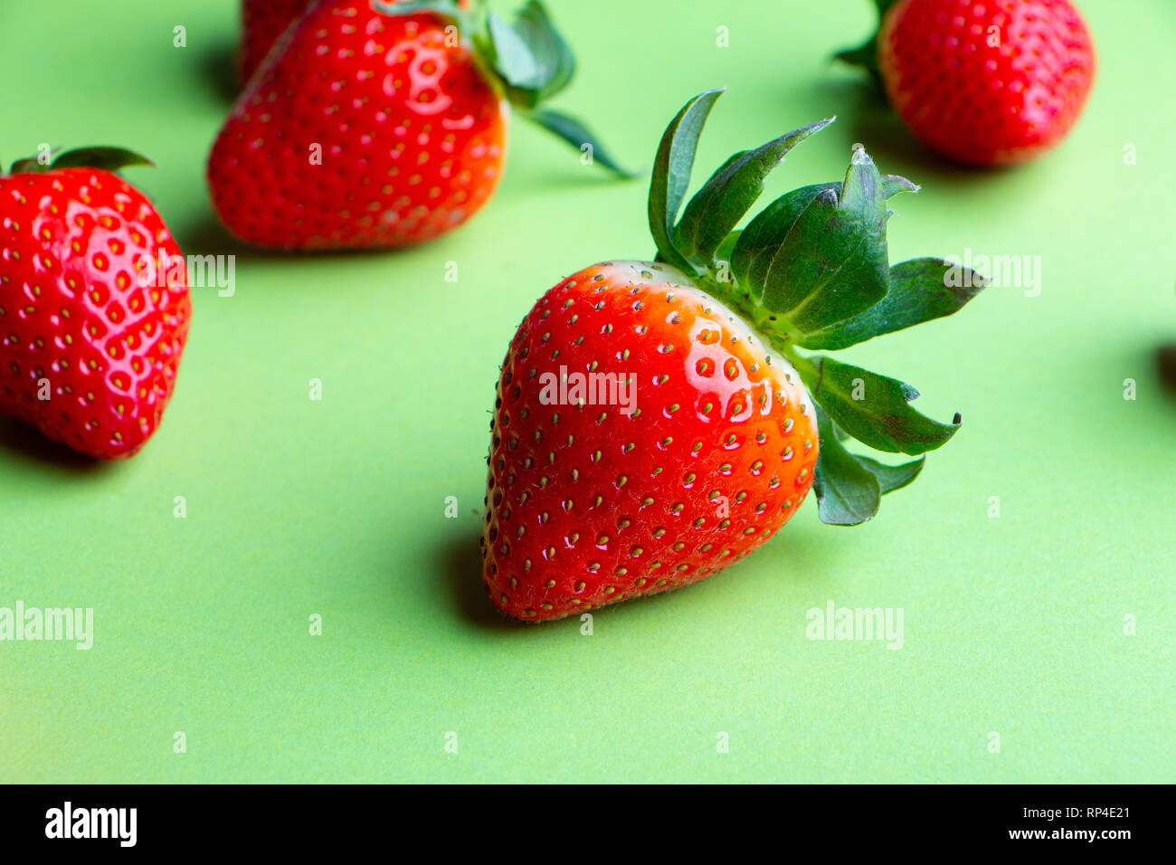 Haufen von frischen Erdbeeren auf grünem Hintergrund Nahaufnahme Stockfoto