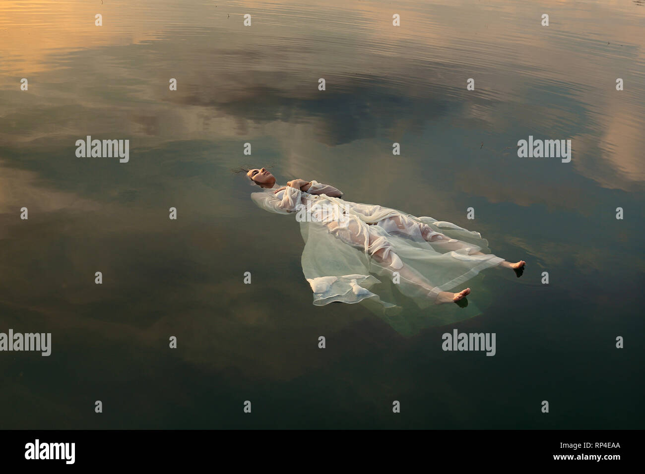 Schwimmende tote Braut im Sonnenuntergang farbigen Wasser Stockfoto