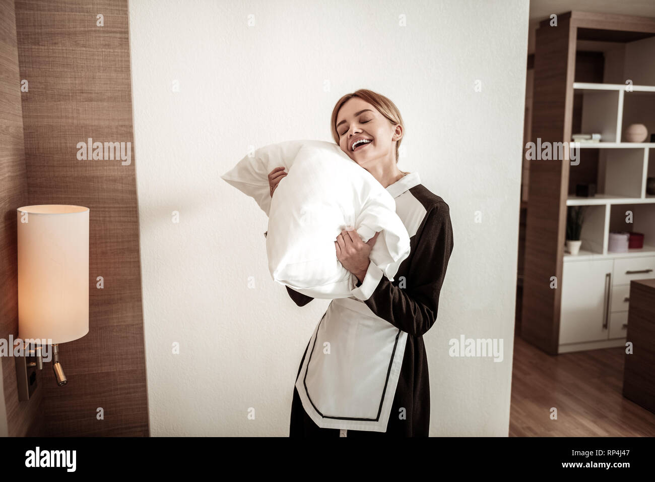 Junge lächelnde Haushälterin Träumen des Schlafes während der Arbeit Stockfoto