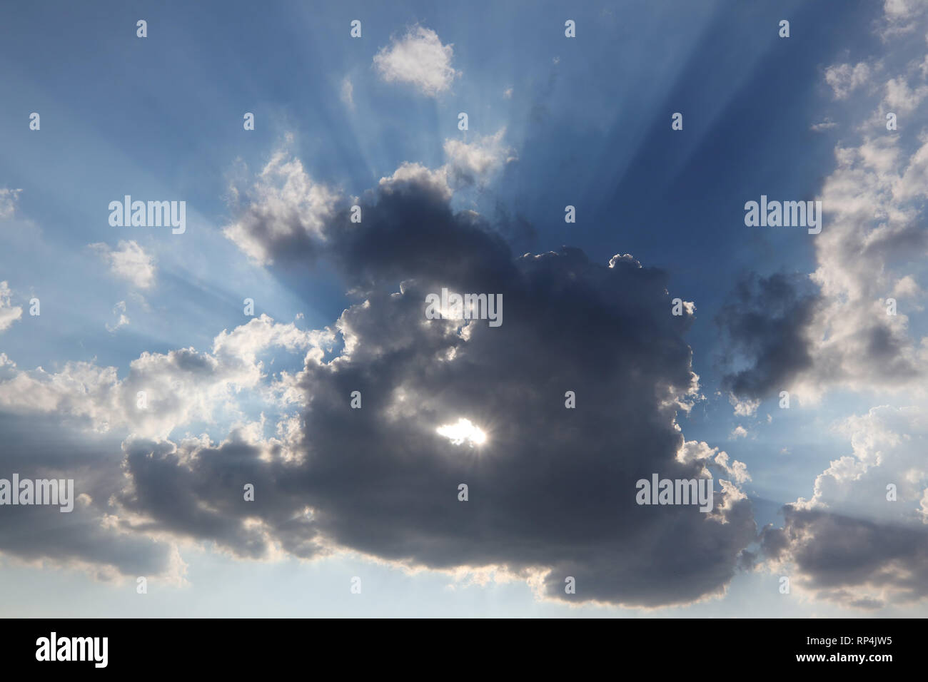 Sonne hinter der Wolke mit einer Bohrung - Sonnenstrahlen. Stockfoto