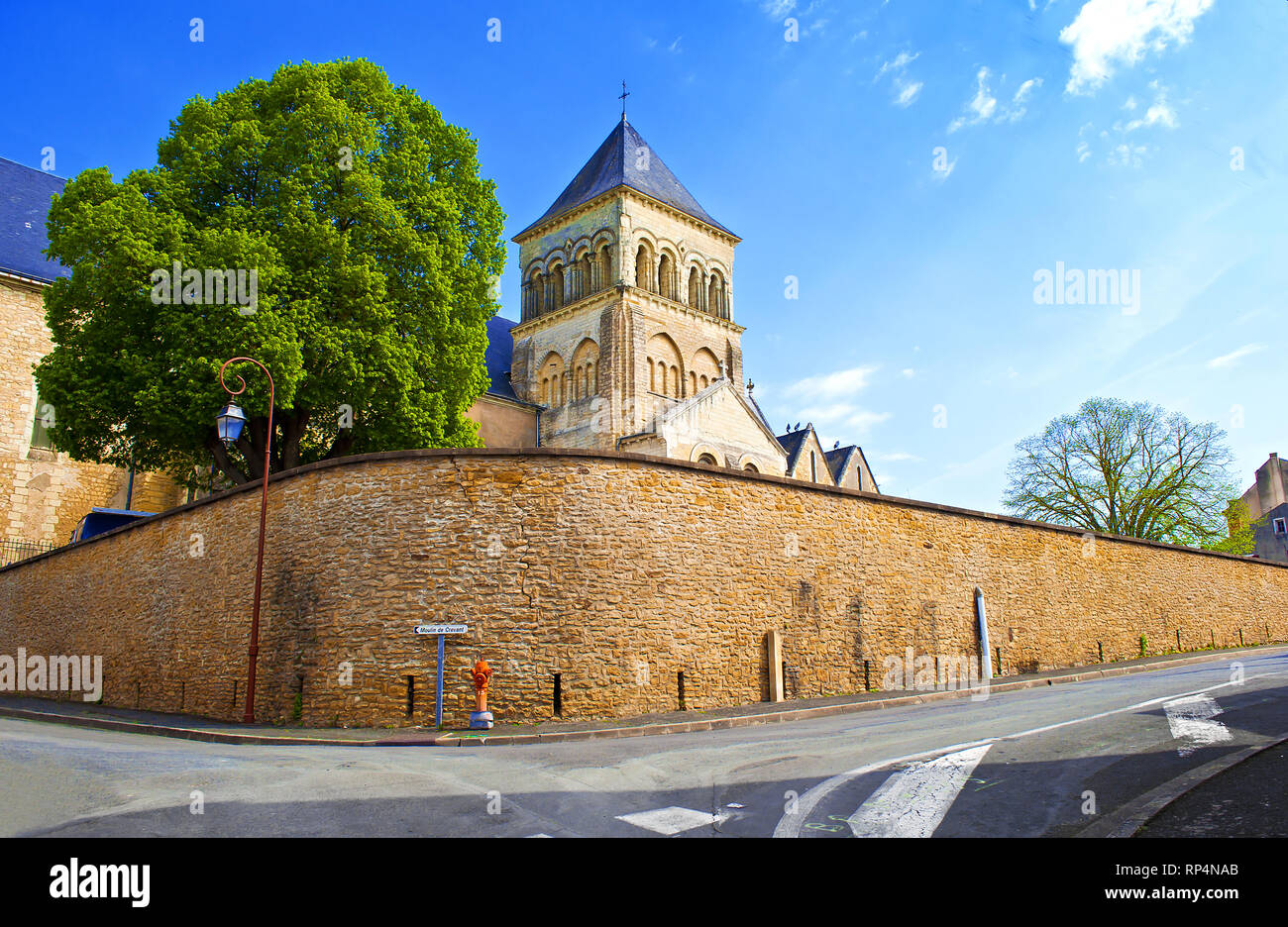 Kirche Saint-Laon und umgebende Mauer in einer kleinen Stadt Thouars, Frankreich. Hoher Turm mit blauem Dach. Warme Frühling Morgen, vibrant blue sky, einer riesigen tr Stockfoto