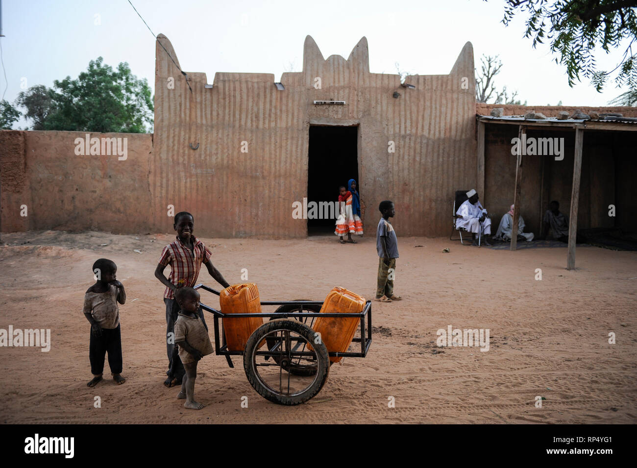 NIGER, Sahel, Zinder, Moschee und die Wasserversorgung im Dorf BABAN TAPKI/Wasserversorgung, Dorfbewohner holen Wasser von einem Brunnen Stockfoto