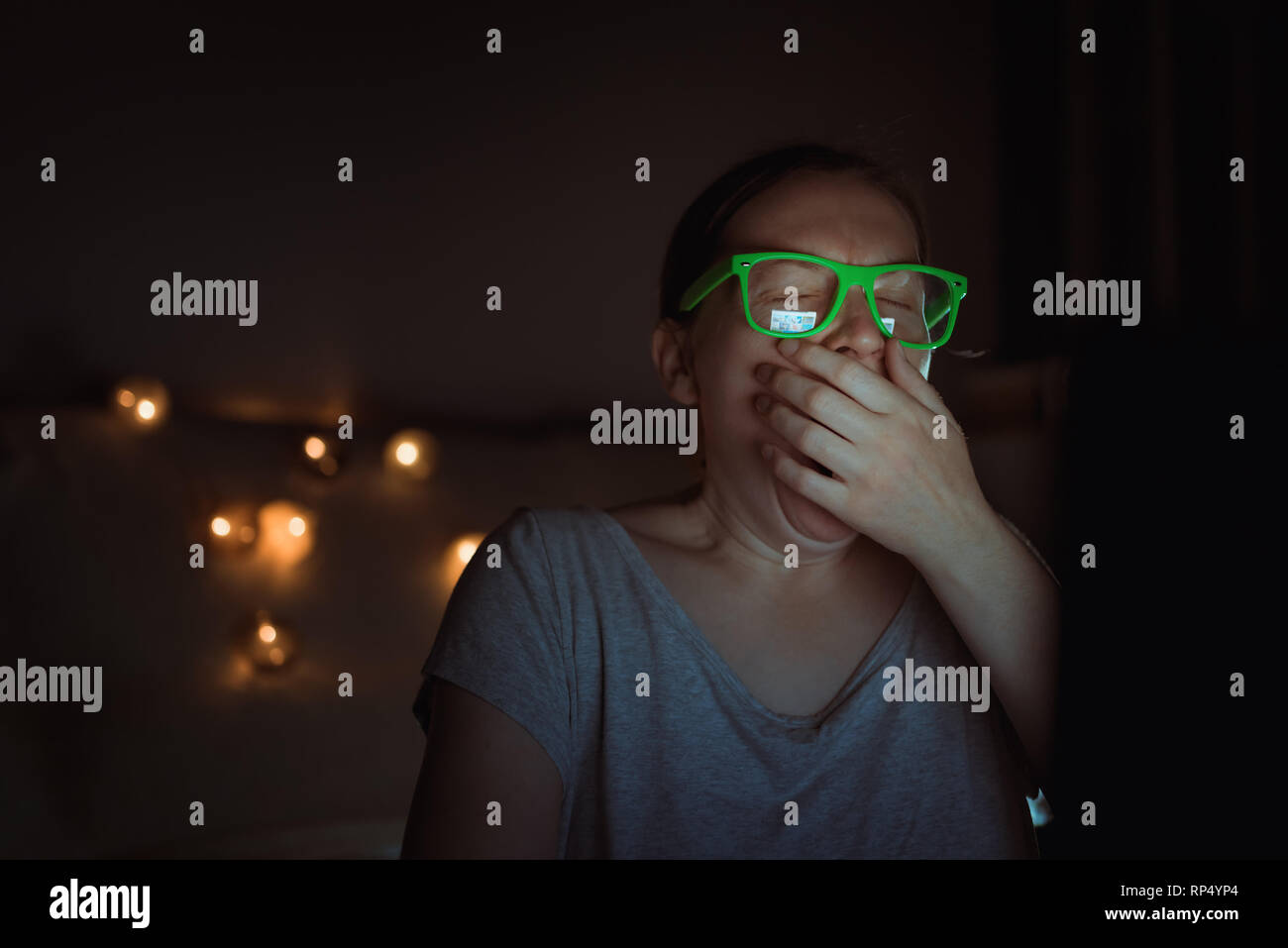 Müde, erschöpft, Freiberufler Frau auf Laptop Computer funktioniert und Gähnen spät in der Nacht in Ihr Büro zu Hause Stockfoto