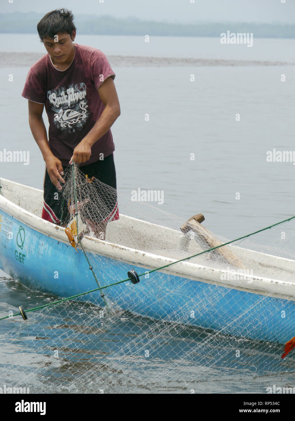 El Salvador ADECHEPET Projekt. (Associascion de Desarrollo Comunal Hermanos Residentes en el Exterior Puerto El Triunfo). Besuchen Fischer in der Nähe Isla El Espiritu Santo. Sie sind IAF begünstigte, hatte Hilfe mit Netzen und Außenbordmotoren. Junge fischer Julio Cesar (15) bei der Arbeit in seinem Boot. Stockfoto