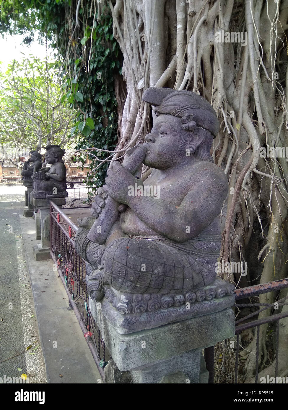 Ubud-Sculpture einer Flöte Spieler im Pura Taman Pule Mas Tempel Stockfoto
