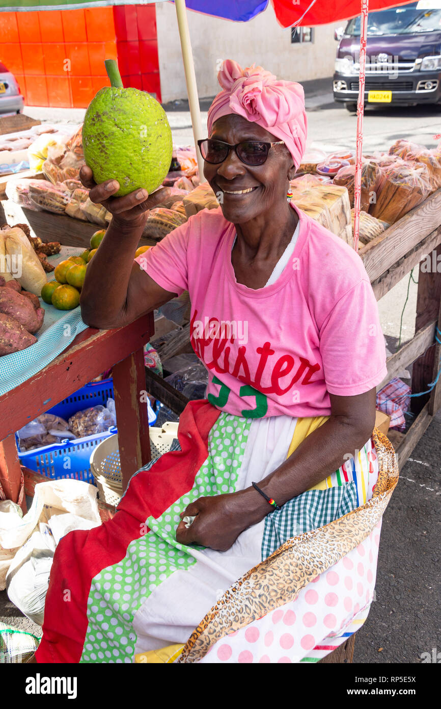 Obst Verkäufer holding Brotfrucht in der St. George's Gemüse, Gewürz & Handwerk Markt, Markt Hill, St. George's, Grenada, Kleine Antillen, Karibik Stockfoto