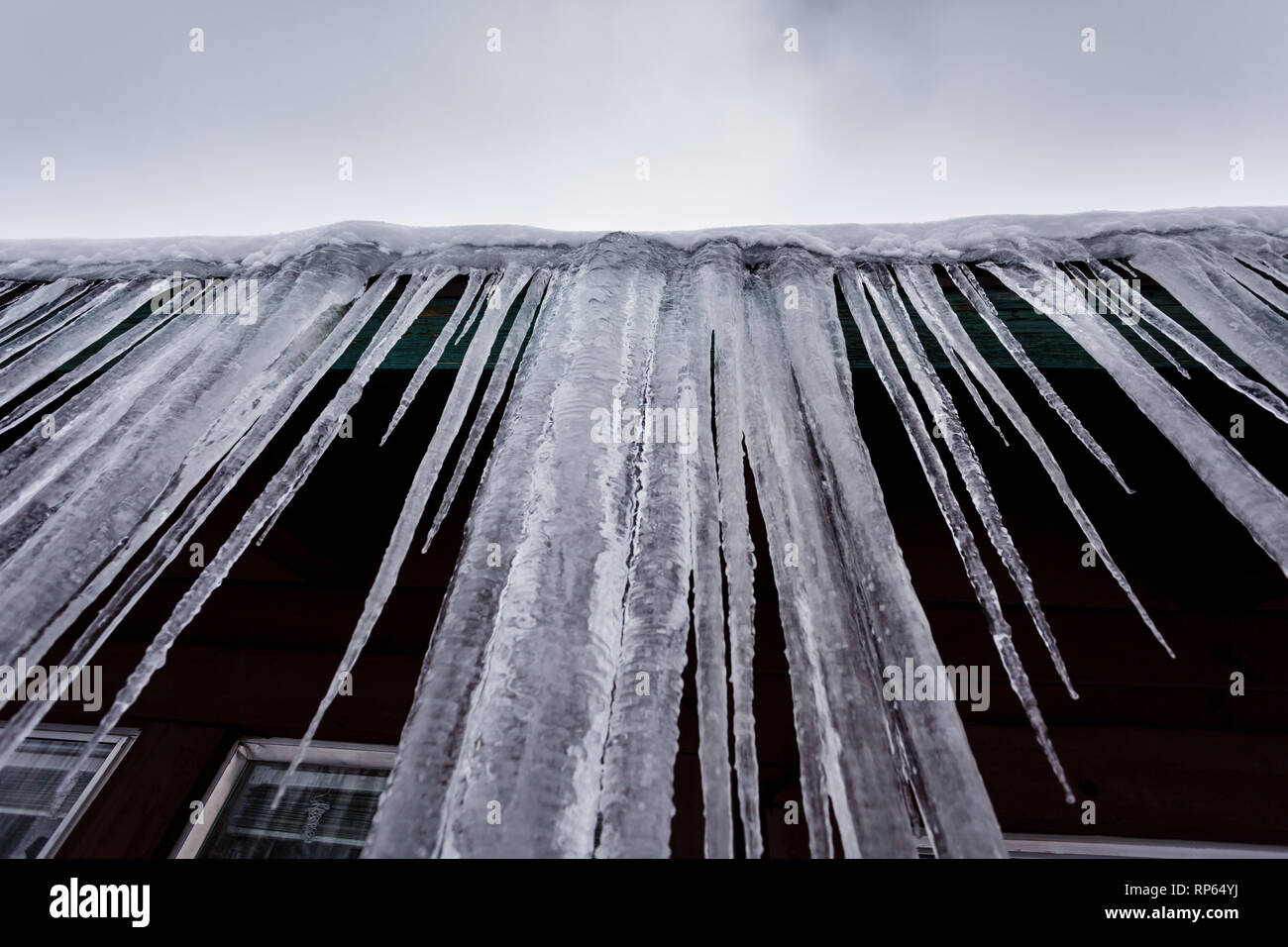 Nahaufnahme der winterlichen Dachdekoration in Lake Tahoe lange tropfende Eiszapfen, die vom Dachrand hängen Stockfoto