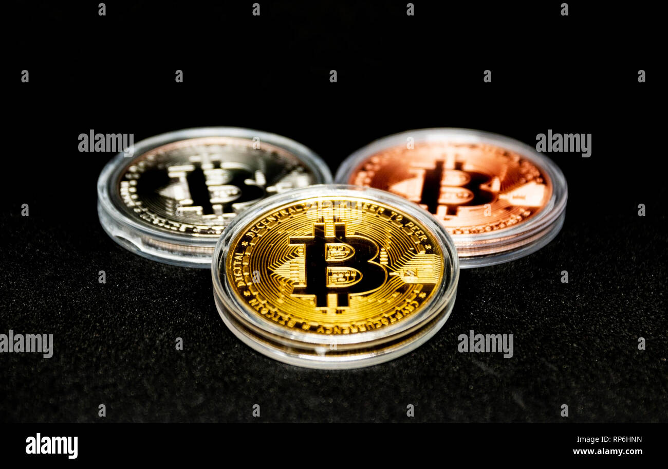 Drei Bitcoins, Gold, Silber und Bronze mit einem schwarzen Hintergrund in klaren Schutzhüllen. Stockfoto