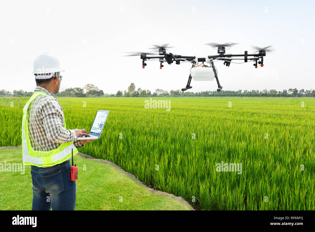 Techniker Landwirt für Wifi verwenden Computer steuern Landwirtschaft Drohne fliegen Dünger auf den Reisfeldern zu gesprüht, Smart Farm 4.0 Konzept Stockfoto