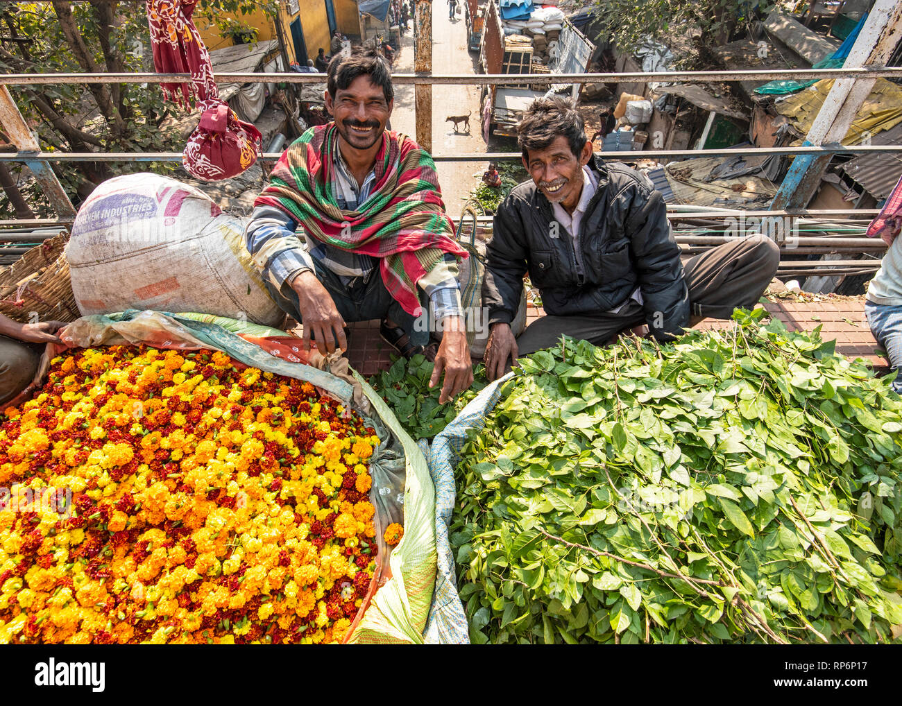 2 Zwei glücklich lächelnde Männer männliche lokale Blumenverkäufer am Mullick Ghat Blumenmarkt posieren für die Kamera. Stockfoto