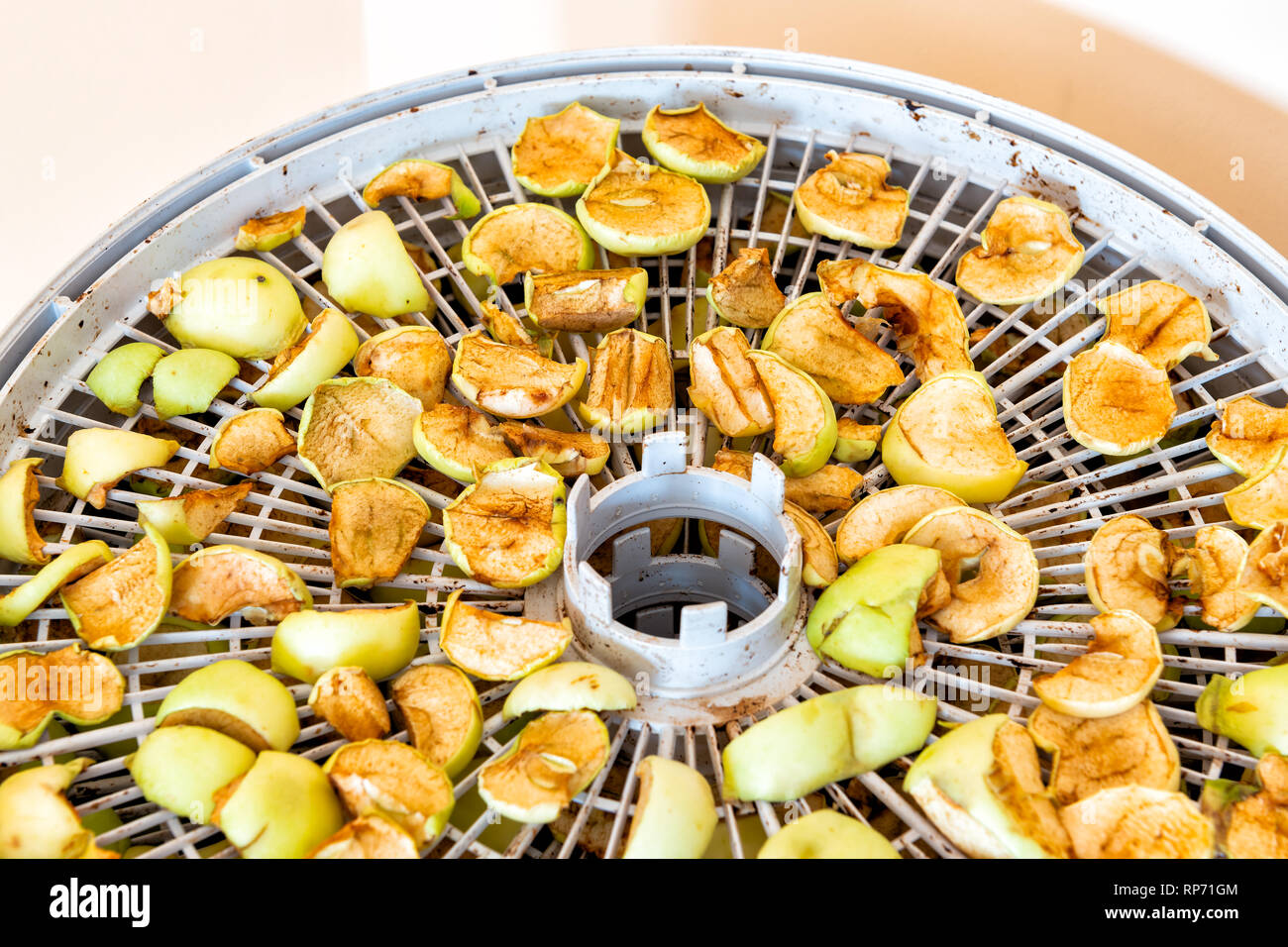 Dehydriert grün gelb golden delicious Trocken hausgemachte Stücke Apfel Obst Schichten an der Trocknerflasche Fach kreisförmige Detailansicht Stockfoto