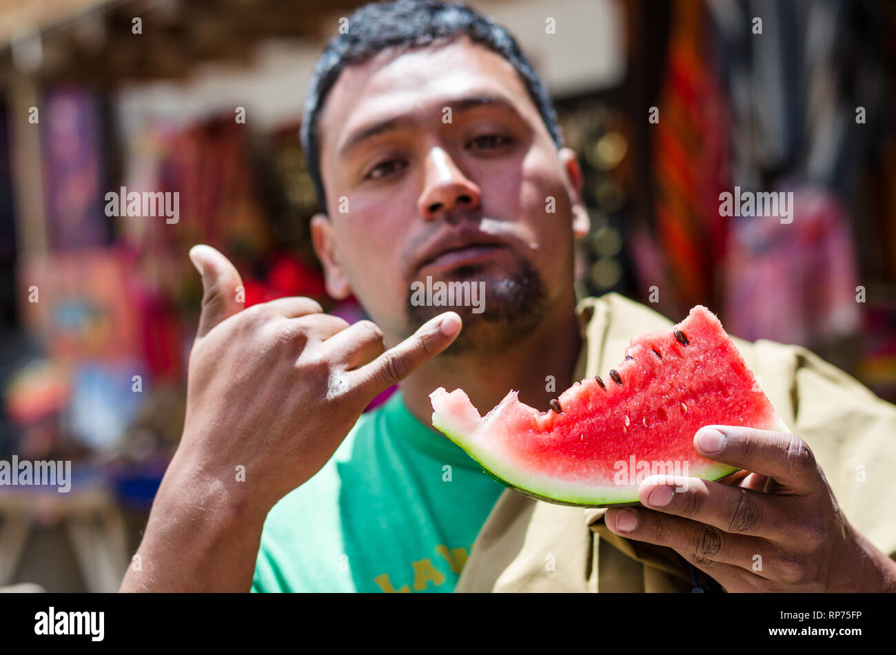 Elegante dunkelhaeutigen Jungen Mann selbst erfrischend im Sommer Tag, Essen reife Wassermelone. Stockfoto