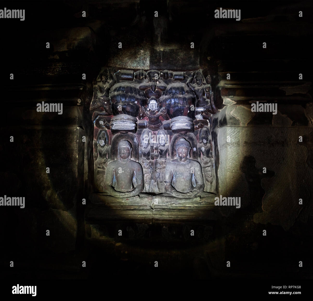 Geschnitzte Statuen des alten hinduistischen Götter beleuchtet mit einer Taschenlampe in einem dunklen Ellora Höhle in der Nähe von Aurangabad, Maharashtra, Indien Stockfoto