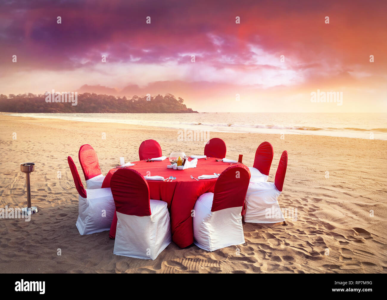 Schöne romantische Roten Wedding Table am tropischen Strand bei purple Sunset Stockfoto
