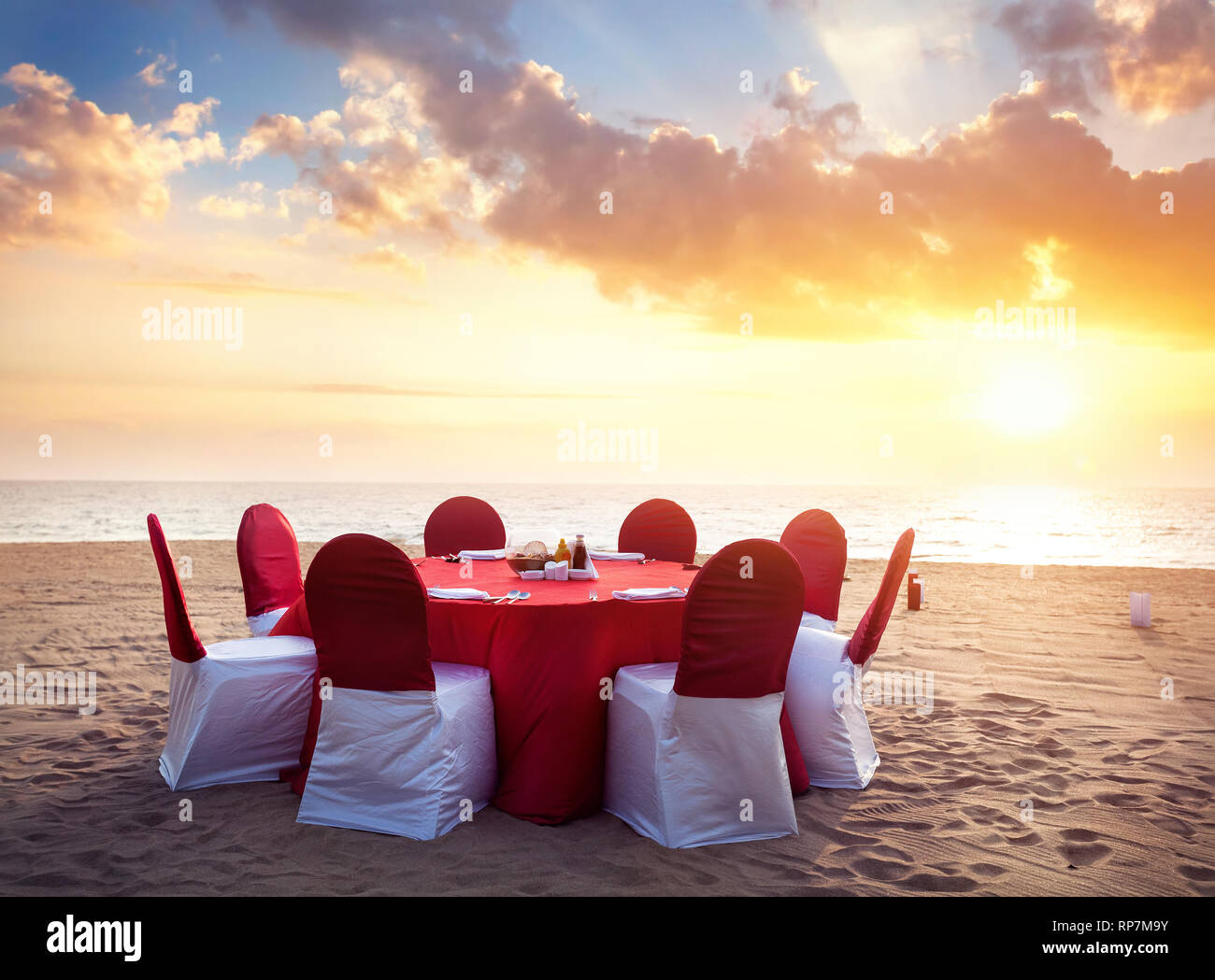 Schöne romantische Roten Wedding Table am tropischen Strand bei Sonnenuntergang Stockfoto