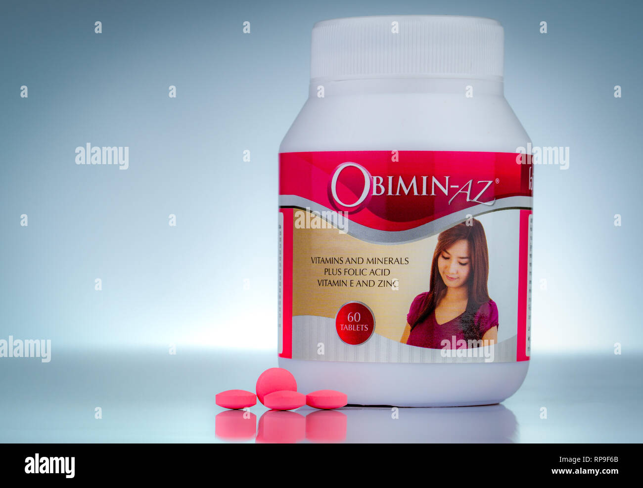 CHONBURI, Thailand - 27. OKTOBER 2018: Obimin - AZ. Vitamine und Mineralien plus Folsäure, Vitamin E und Zink in der Droge Flasche auf farbverlauf Hintergrund. Rosa Stockfoto