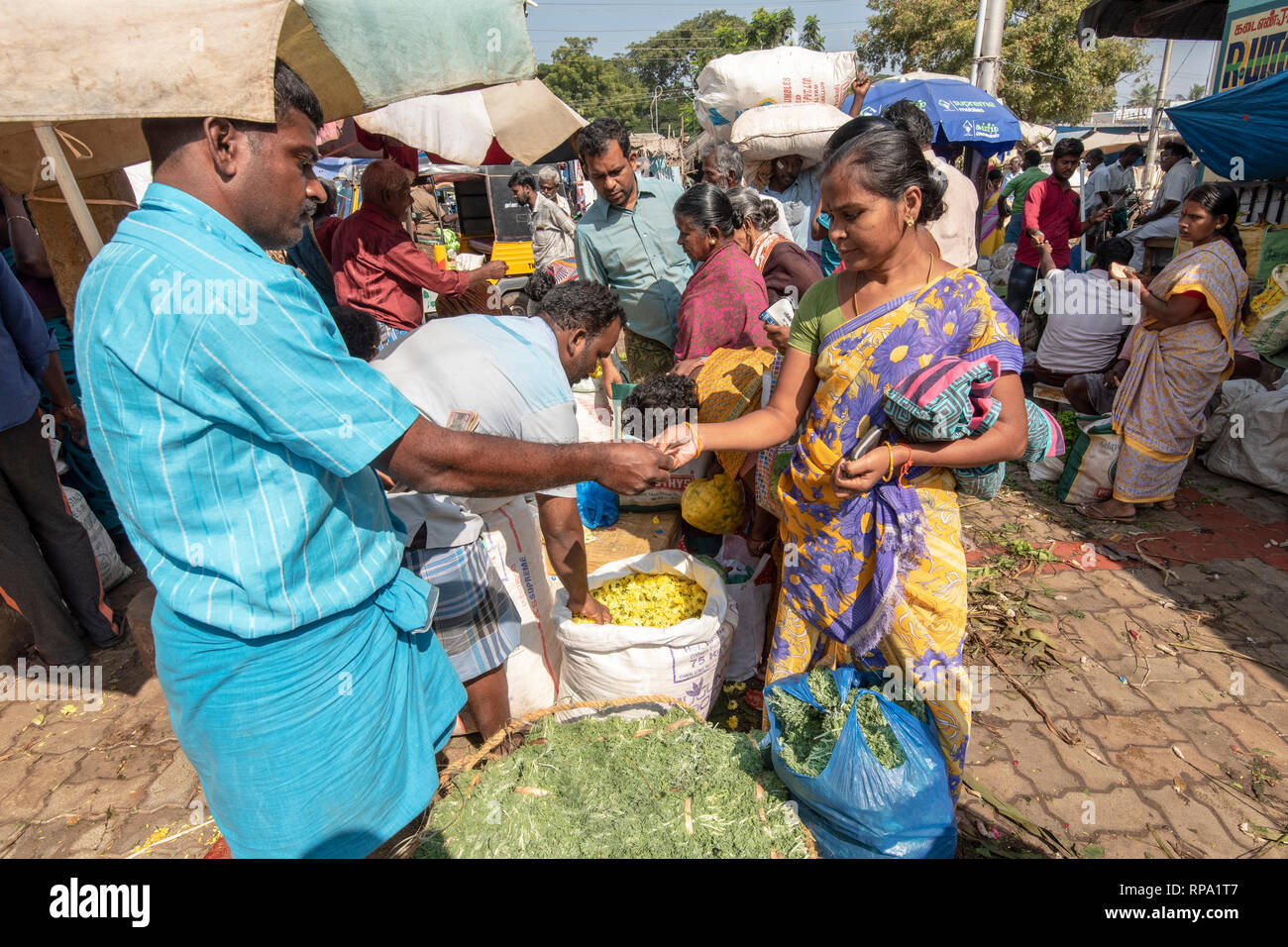 Ein Käufer von Blumen der Übergabe des Geldes an den Verkäufer für eine Transaktion an der belebten belebten Madurai Blumenmarkt. Stockfoto