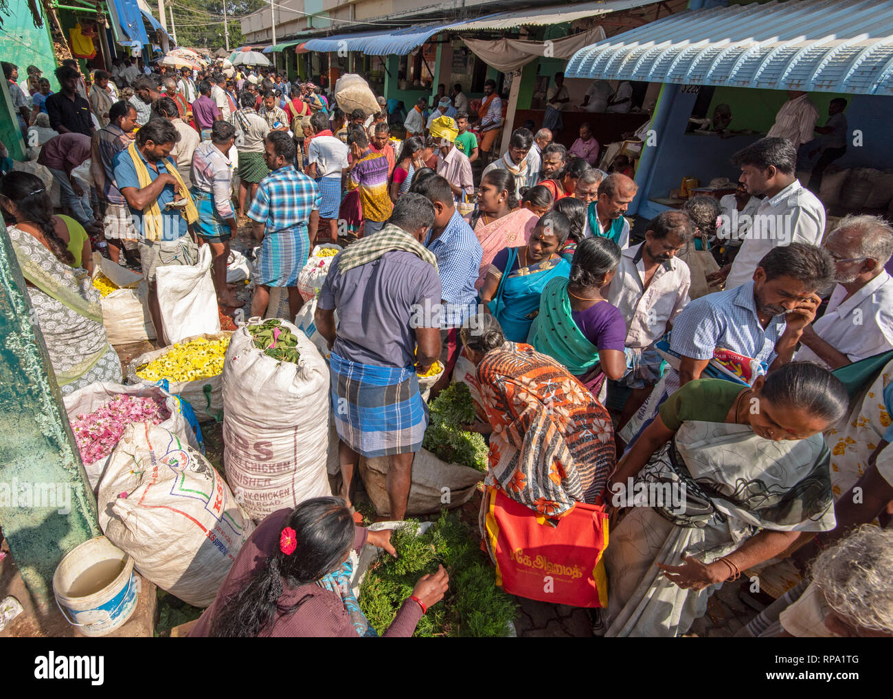 Eine Ansicht besetzt geschäftigen Menschen, einheimische Handel Kauf Verkauf von Blumen am Madurai Blumenmarkt in Indien. Stockfoto