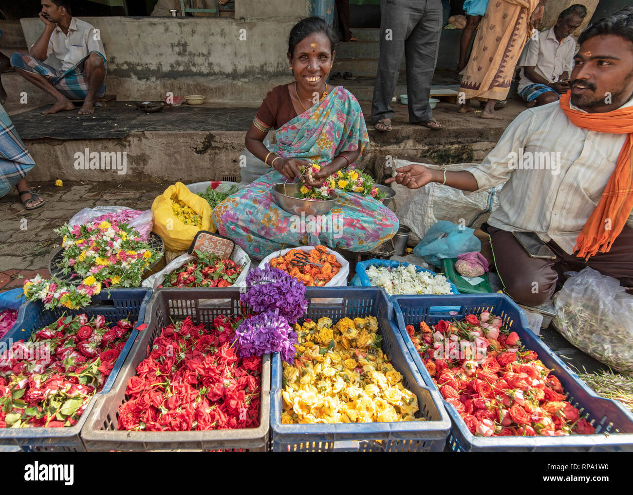 Ein Händler Verkäufer von Blumen lächeln und für die Kamera an der belebten Madurai Blumenmarkt in Indien posieren. Stockfoto