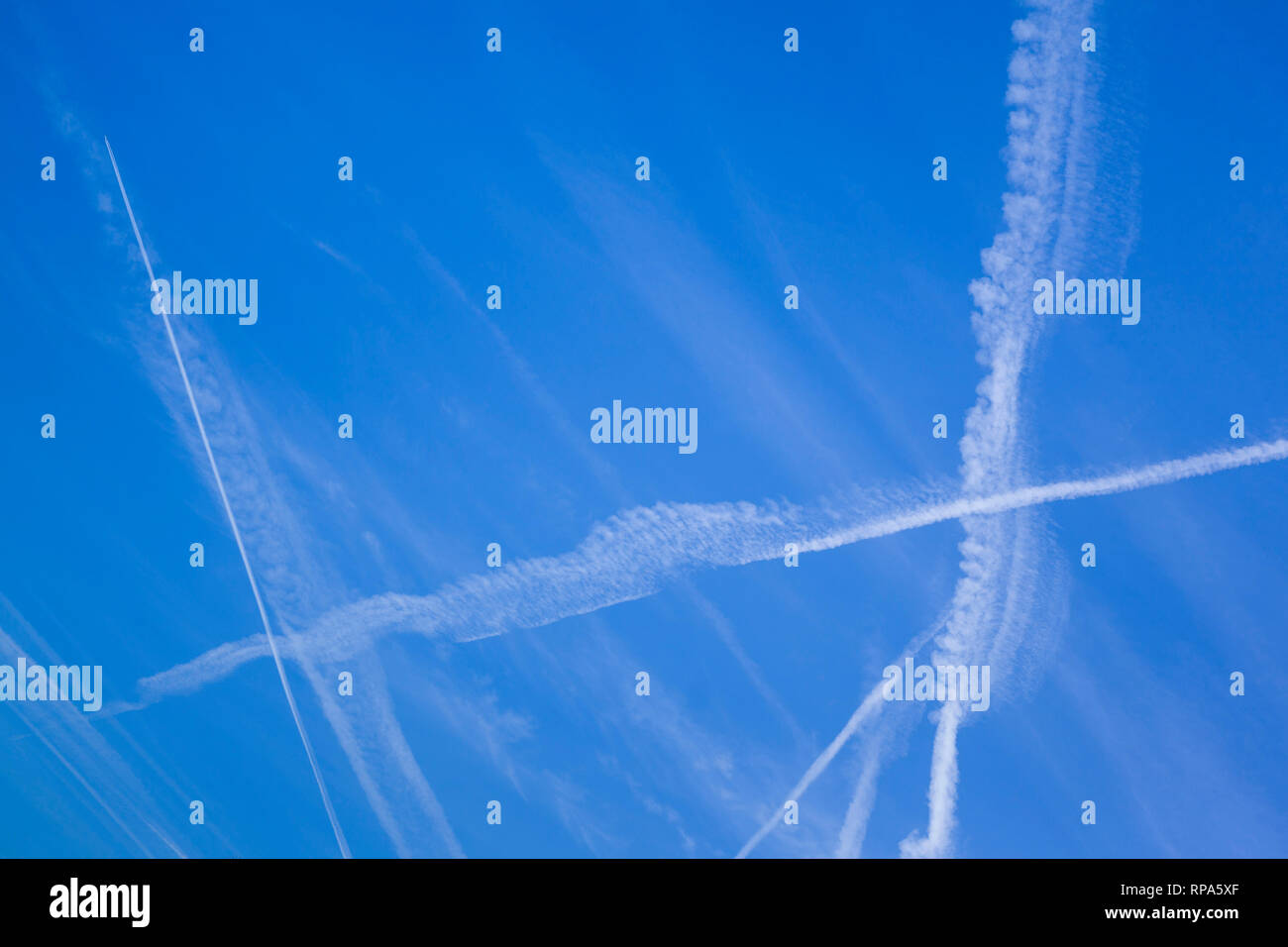Abstrakte Muster von Kondensstreifen in den blauen Himmel, die manchmal als kondensstreifen oder Kondensstreifen bekannt. Stockfoto