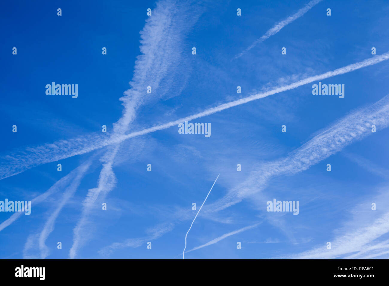 Abstrakte Muster von Kondensstreifen in den blauen Himmel, die manchmal als kondensstreifen oder Kondensstreifen bekannt. Stockfoto