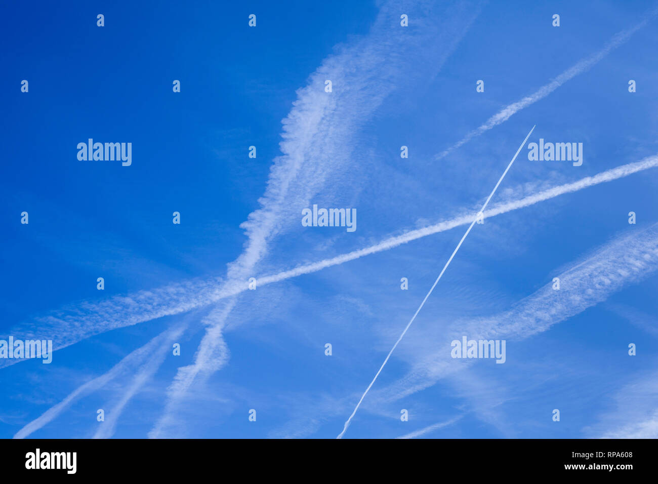 Abstrakte Muster von Kondensstreifen in den blauen Himmel, die manchmal als kondensstreifen oder Kondensstreifen bekannt. Stockfoto