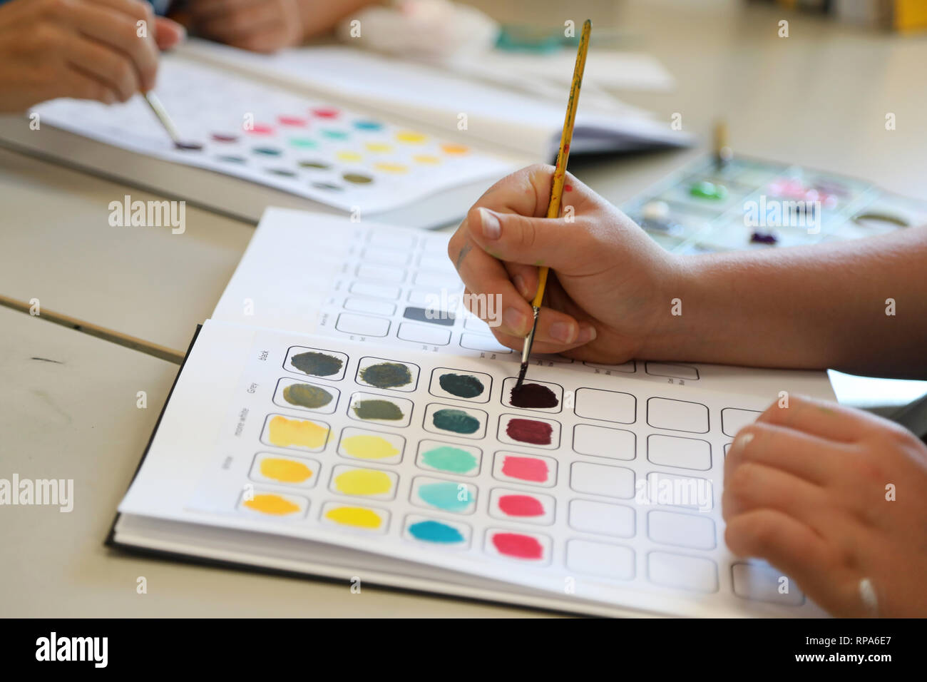 Studierende, die in ihrer visuellen Kunst Prozess Tagebücher erkunden Experimentieren mit Farbe Theorie. Malerei in Arbeitsmappen. Creative Arts Education anhand von quantitativen Simulatio Stockfoto