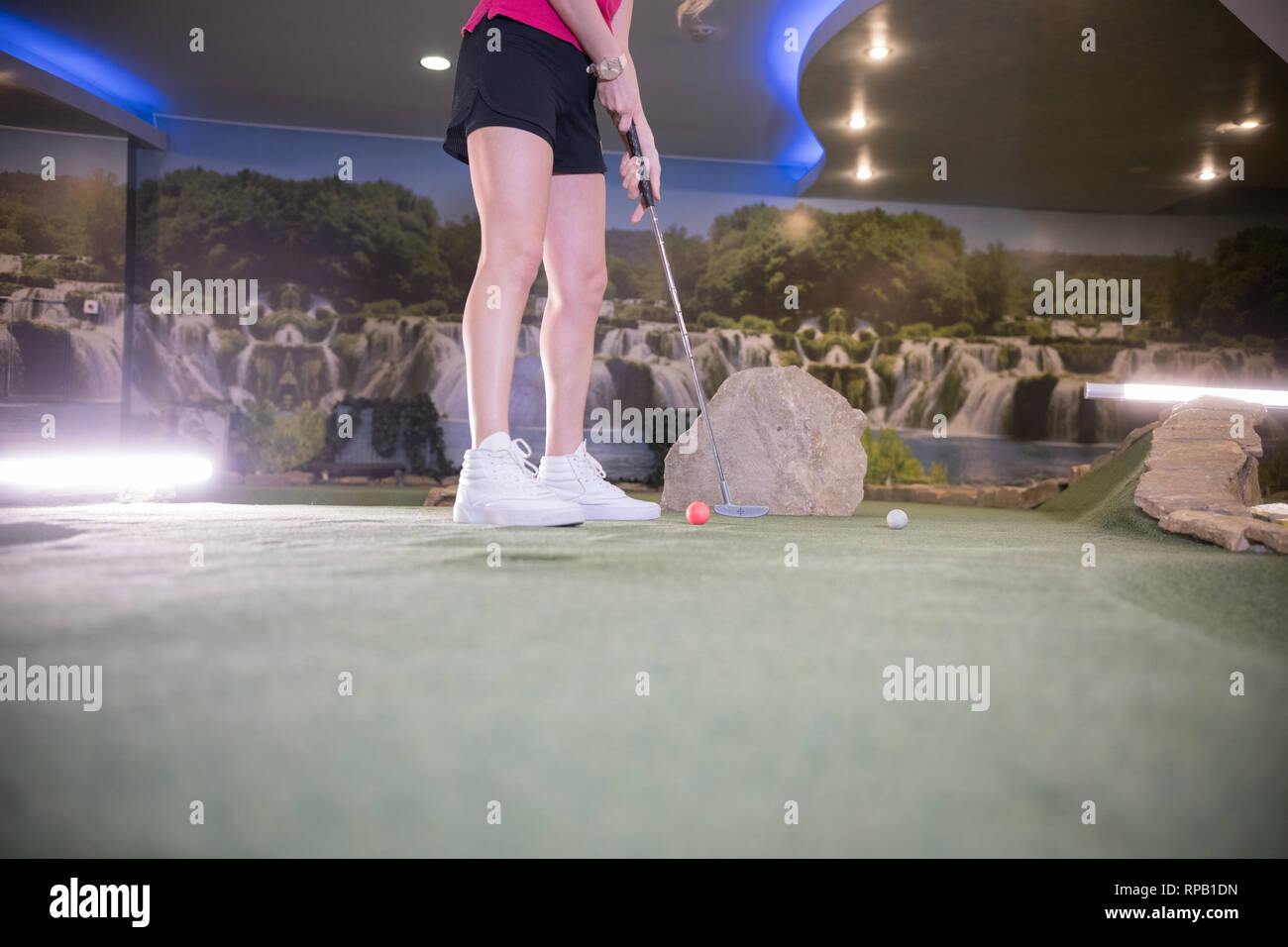 Eine Junge Frau In Weissen Turnschuhen Spielen Mini Golf Zuhause