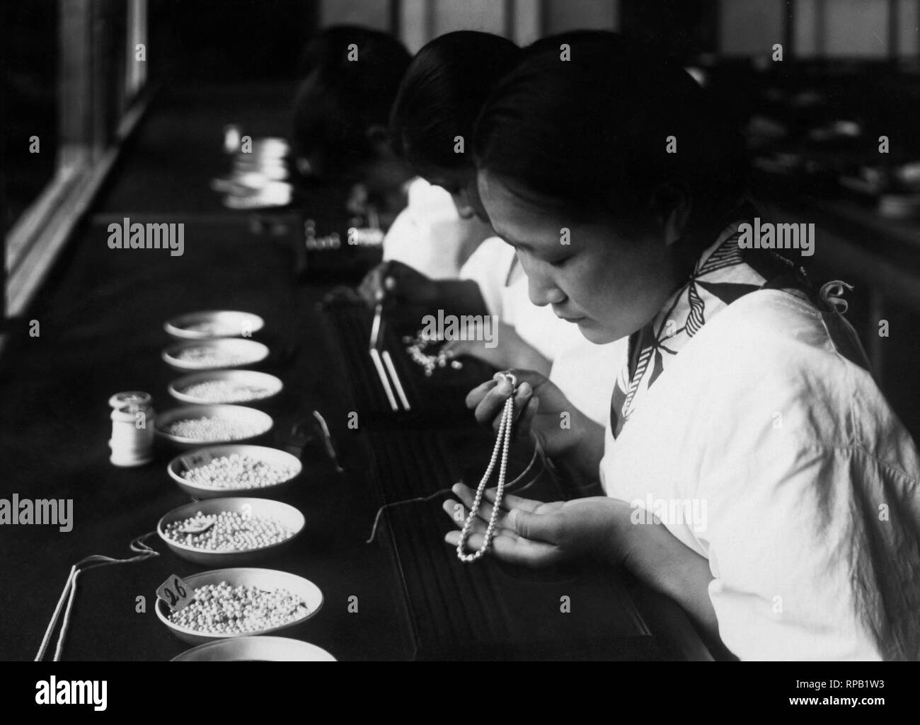Japan, japanische Mädchen schieben Perlen für Halsketten, 1920-30 Stockfoto